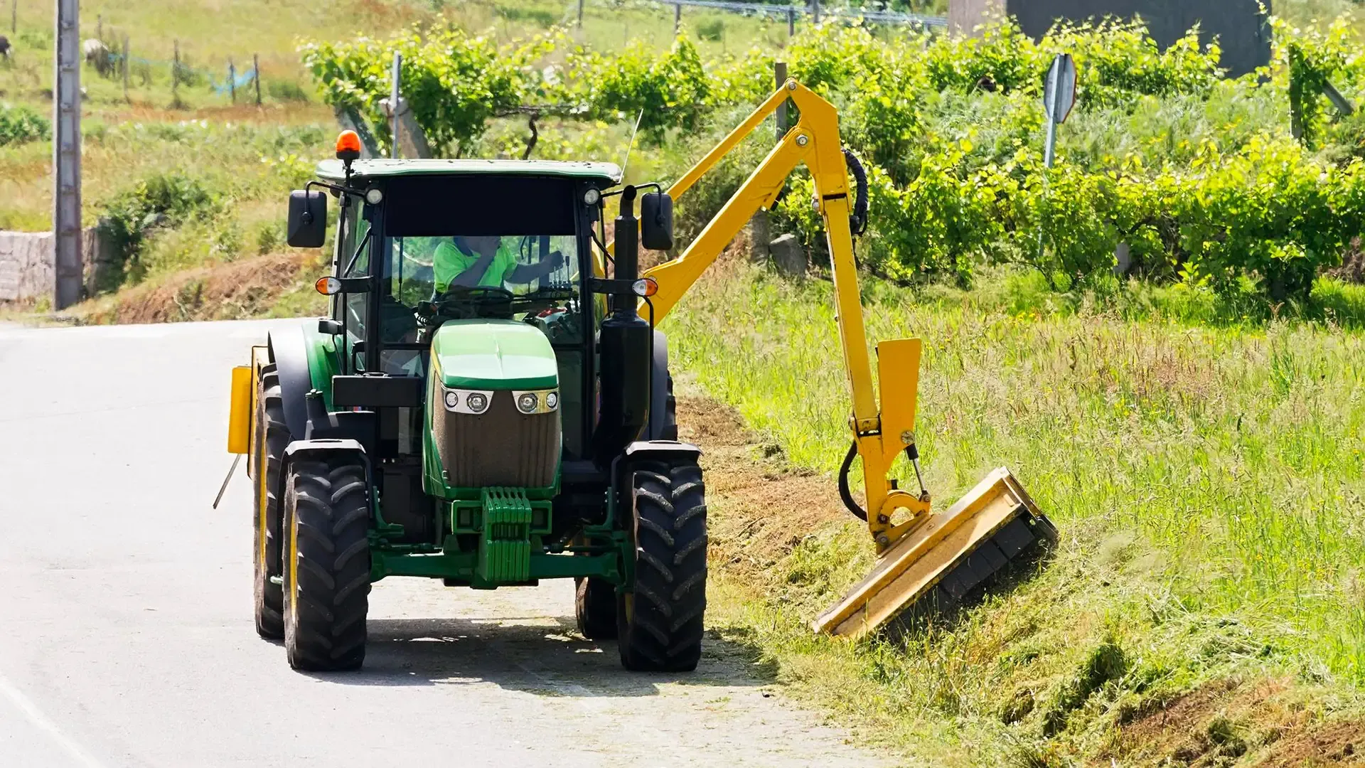 Flail mower maintaining vegetation along a site access route.