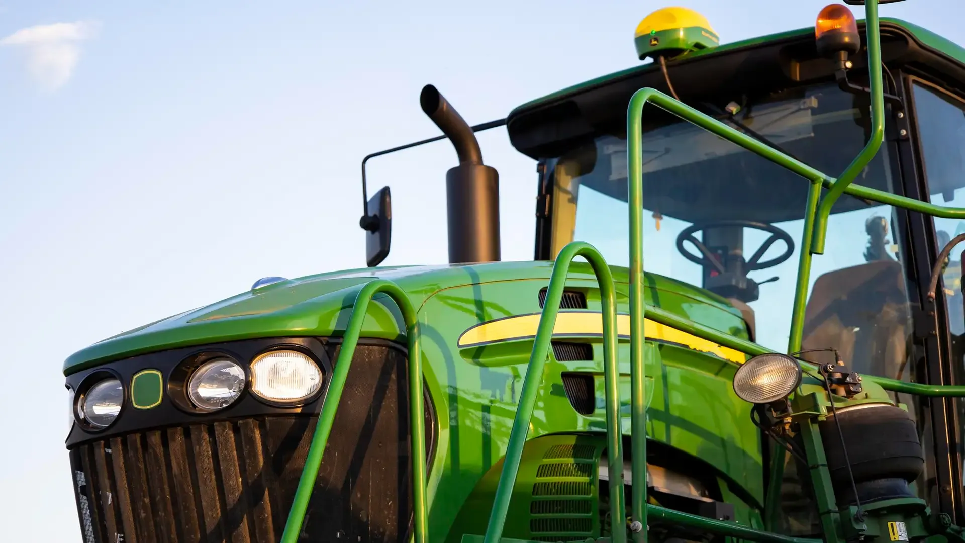 Close-up of tractor cab and grille in the field.
